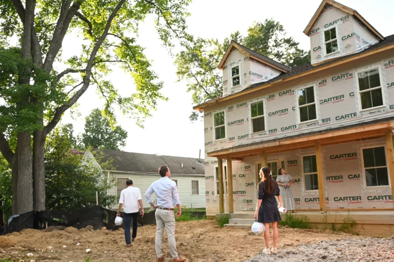 Clients walking a lot with the Character Companies team beside a home under construction