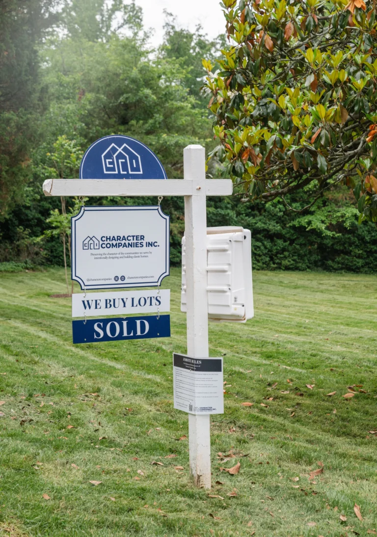 A Character Companies "We Buy Lots" sign marked sold on a grassy lot